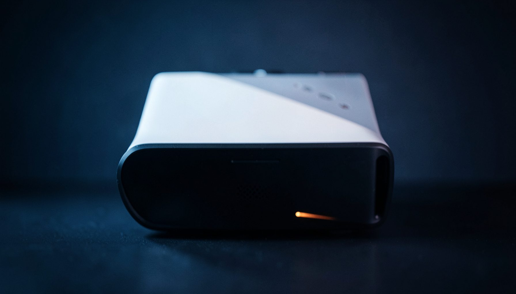 A sleek next-generation gaming console with a white and black two-tone design, soft studio lighting on a dark surface